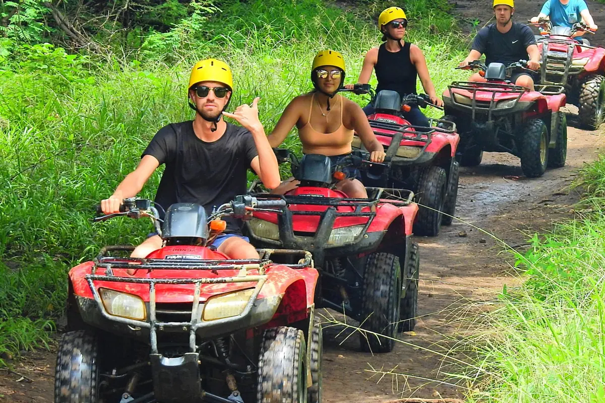 Group riding red Honda ATVs on a forest trail near Playas del Coco
