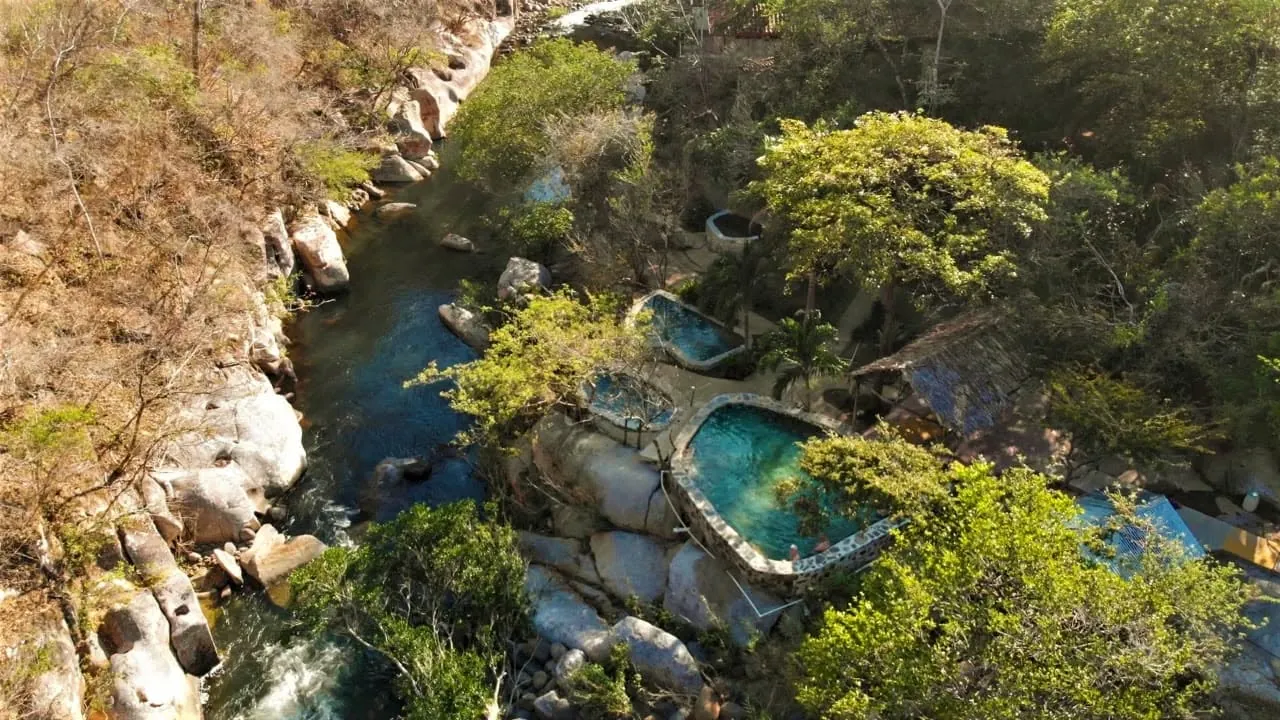 Aerial view of natural hot spring pools beside the river at Cañon de la Vieja in Guanacaste, Costa Rica
