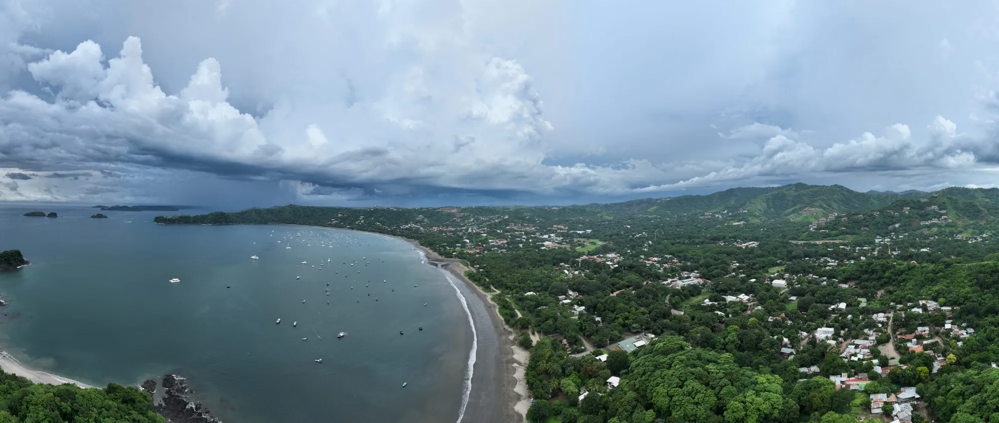 Panoramic aerial view of the Playas del Coco bay and town under a stormy sky